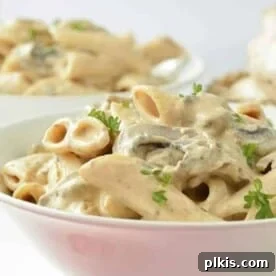finished vegan mushroom pasta plated in a white bowl with another bowl in the background