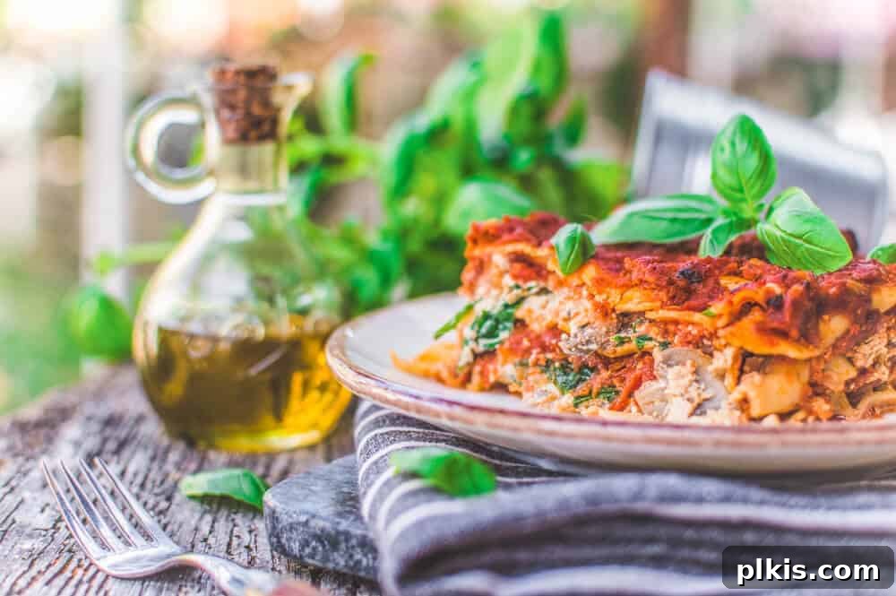 20 Effortless Plant-Based Pasta Dishes for Delicious Dinners 10 Finished Vegan Lasagna With Tofu Ricotta plated on a gray towel with ingredients in the background
