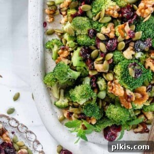 Vegan Broccoli Salad in a white dish, garnished and ready to serve, presented against a clean white background.