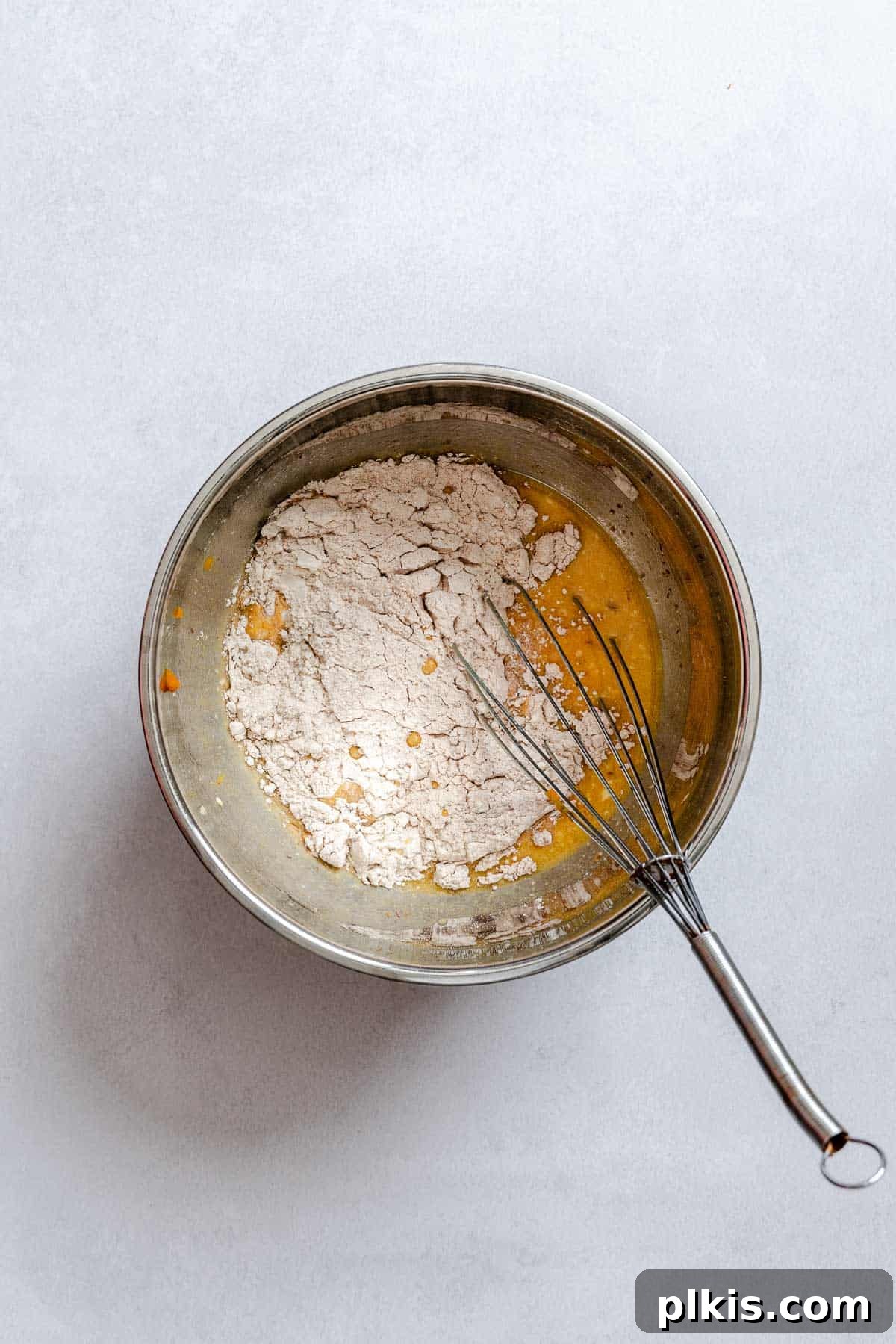Plant-Based Pumpkin Patch Waffles 6 Process shot showing dry ingredients (flour, baking powder, pumpkin spice) being whisked in a separate bowl.
