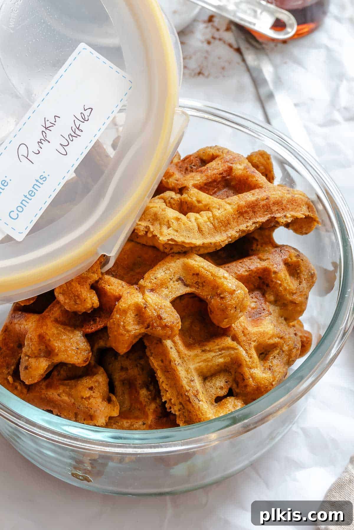 Plant-Based Pumpkin Patch Waffles 9 A stack of completed Vegan Pumpkin Waffles neatly stored in a clear airtight container, ready for future enjoyment.