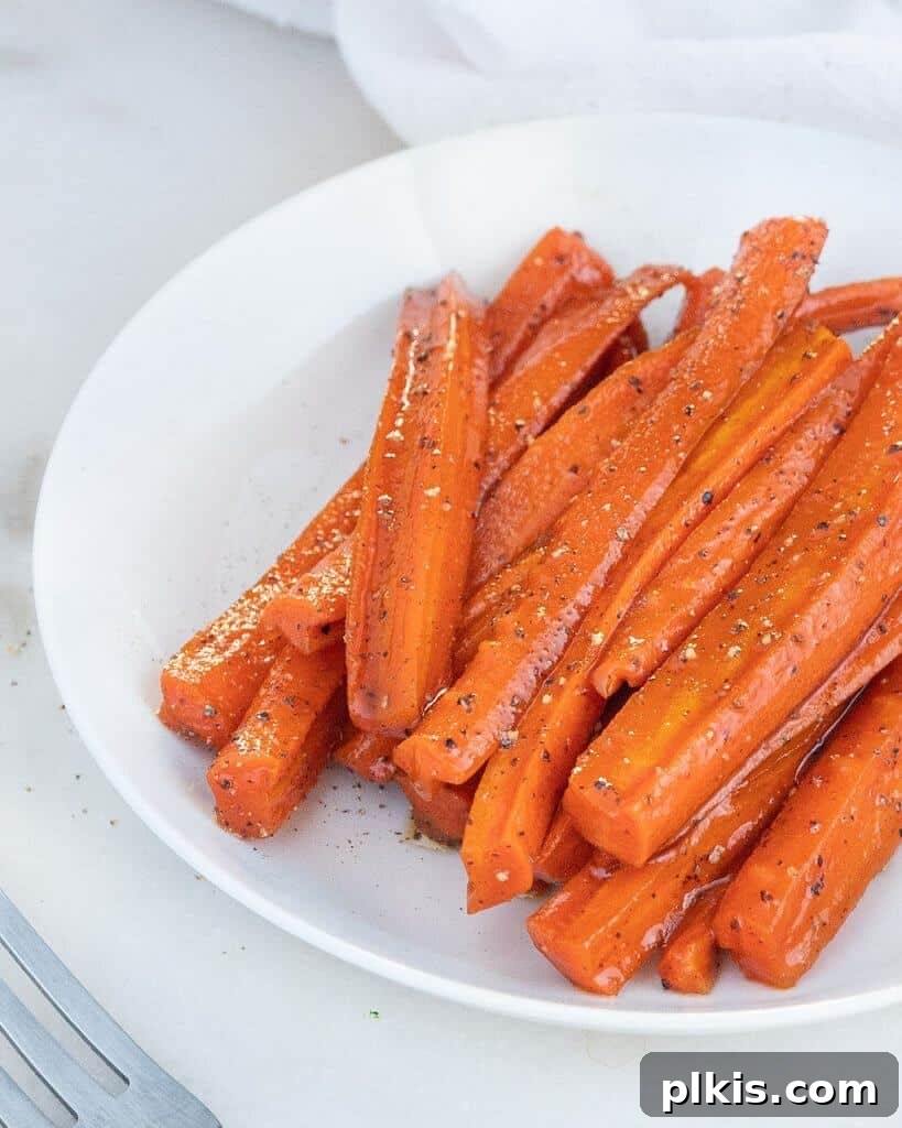 45 Mouthwatering Vegan Thanksgiving Recipes 22 Perfectly glazed carrots arranged on a white plate against a minimalist white background.
