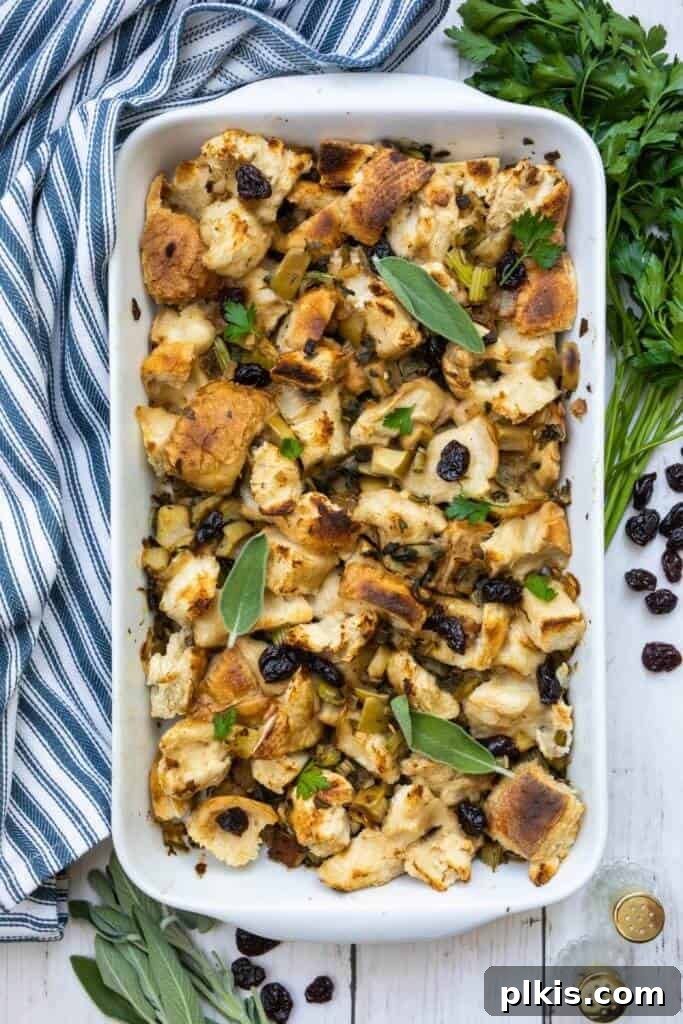 45 Mouthwatering Vegan Thanksgiving Recipes 40 A festive image of finished stuffing in a white baking dish, with a blue towel and fresh herbs in the background.