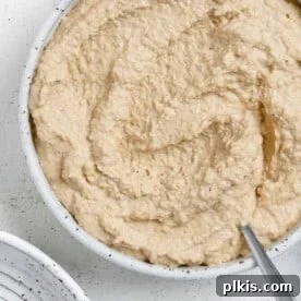 45 Mouthwatering Vegan Thanksgiving Recipes 4 Completed Vegan French Onion Dip in a white bowl against a light background.