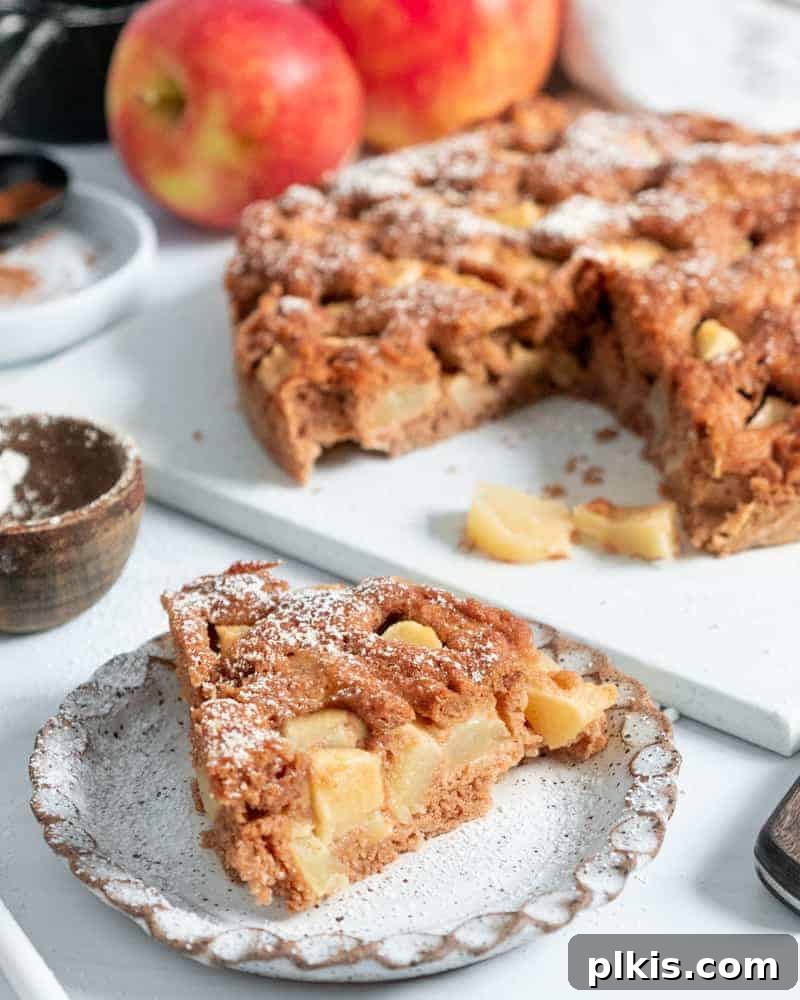 45 Mouthwatering Vegan Thanksgiving Recipes 69 A beautifully finished vegan apple cake, with two fresh apples and measuring tools in the background.