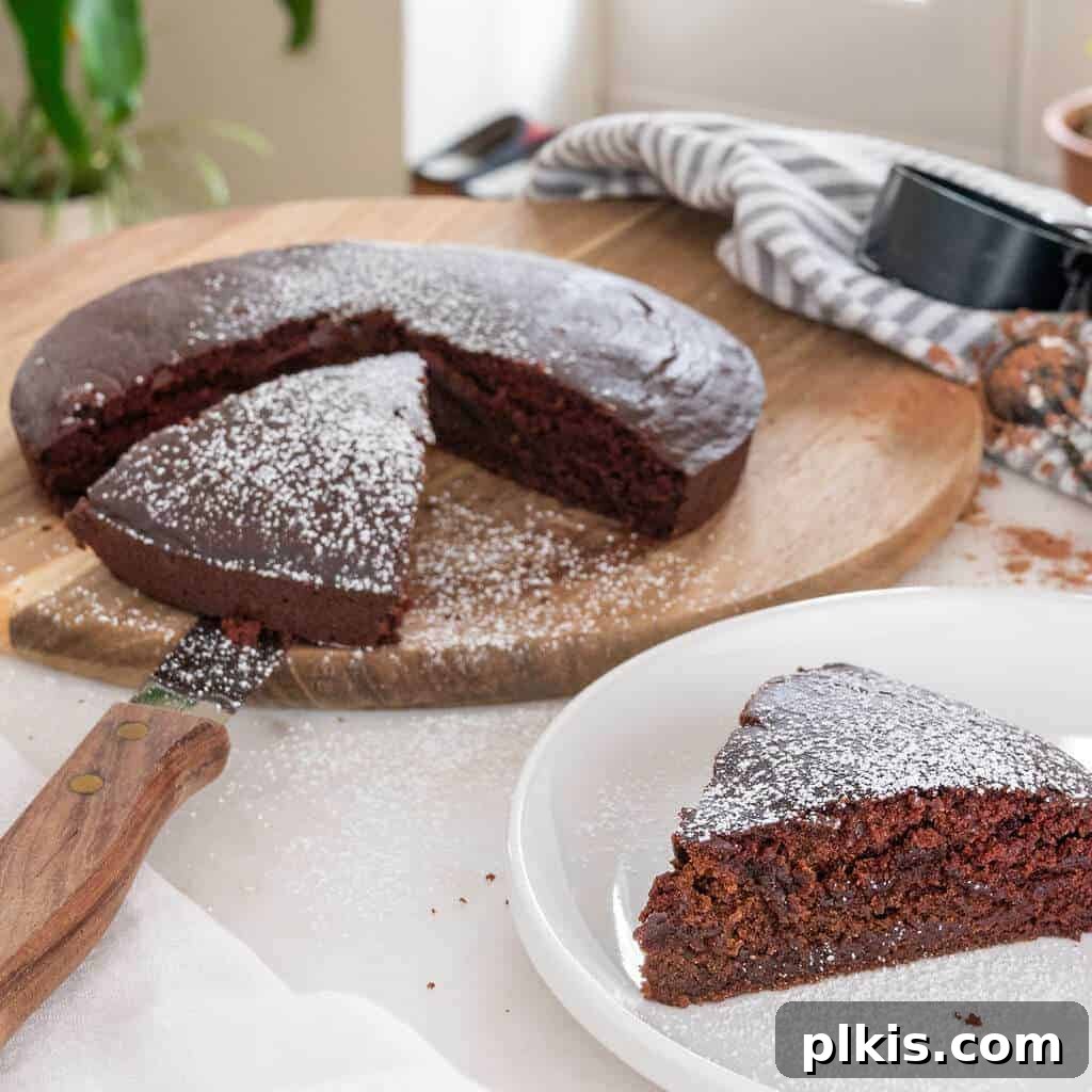 45 Mouthwatering Vegan Thanksgiving Recipes 80 Completed chocolate crazy cake on a cutting board, with two slices already removed.