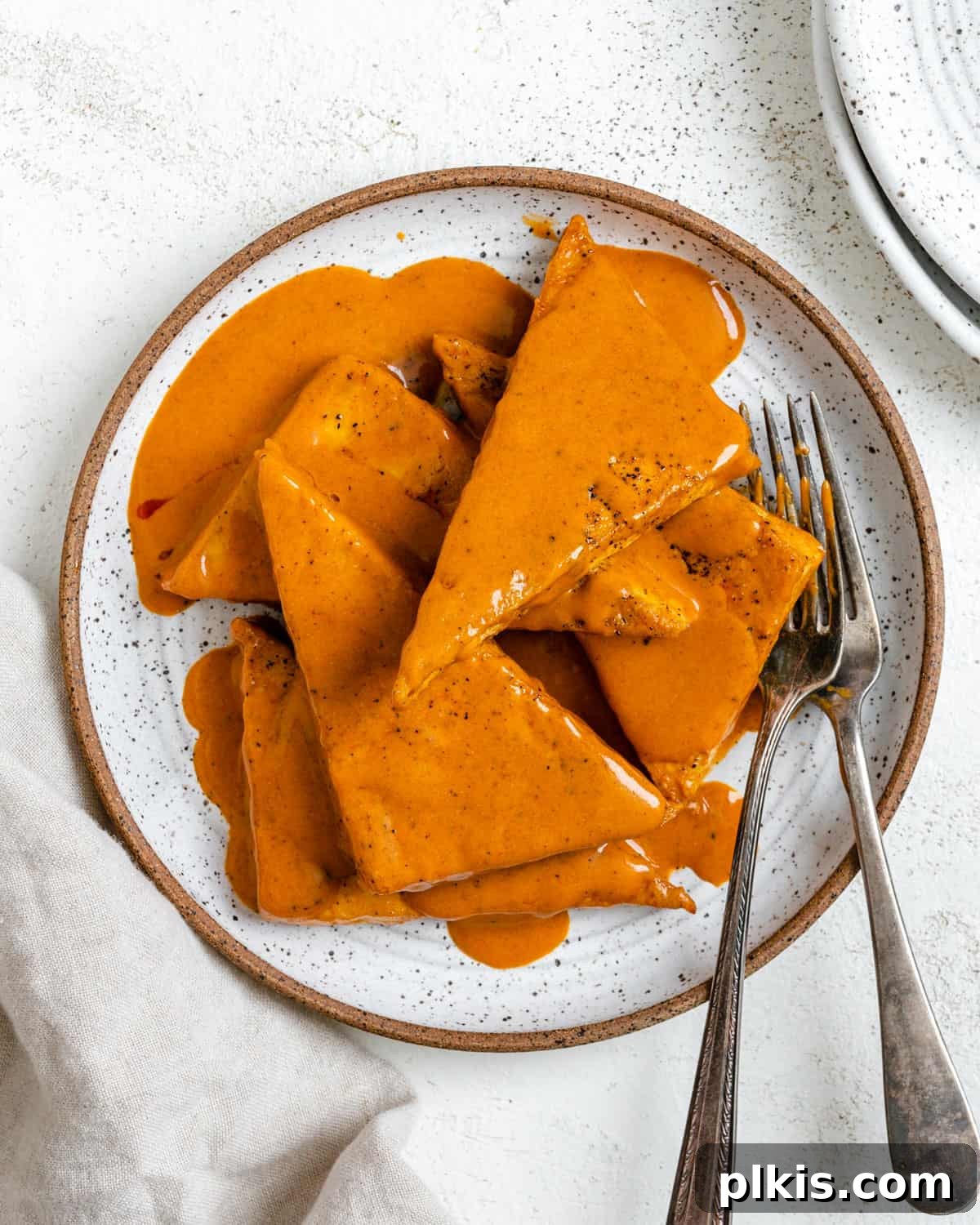 Buffalo Tofu Your Way: Easy Fried, Baked, or Air-Fried 2 Crispy Buffalo Tofu plated on a white dish, garnished with fresh herbs