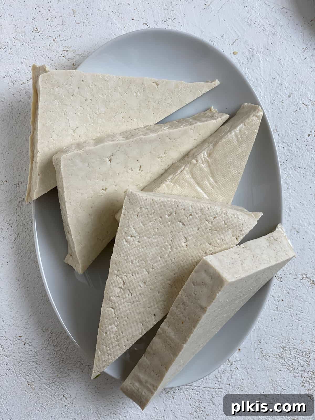 Buffalo Tofu Your Way: Easy Fried, Baked, or Air-Fried 4 Slices of tofu prepared into wedges on a white plate