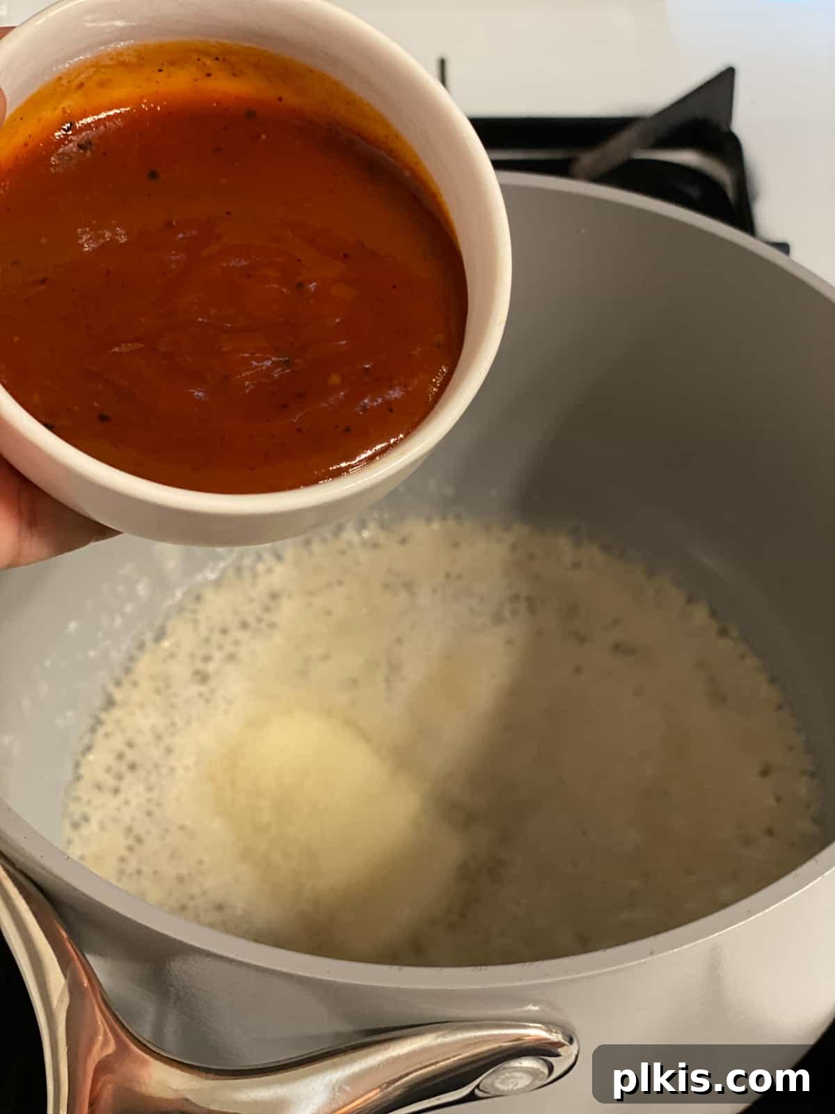 Buffalo Tofu Your Way: Easy Fried, Baked, or Air-Fried 7 Process shot of adding hot sauce to the melted vegan butter in the pan