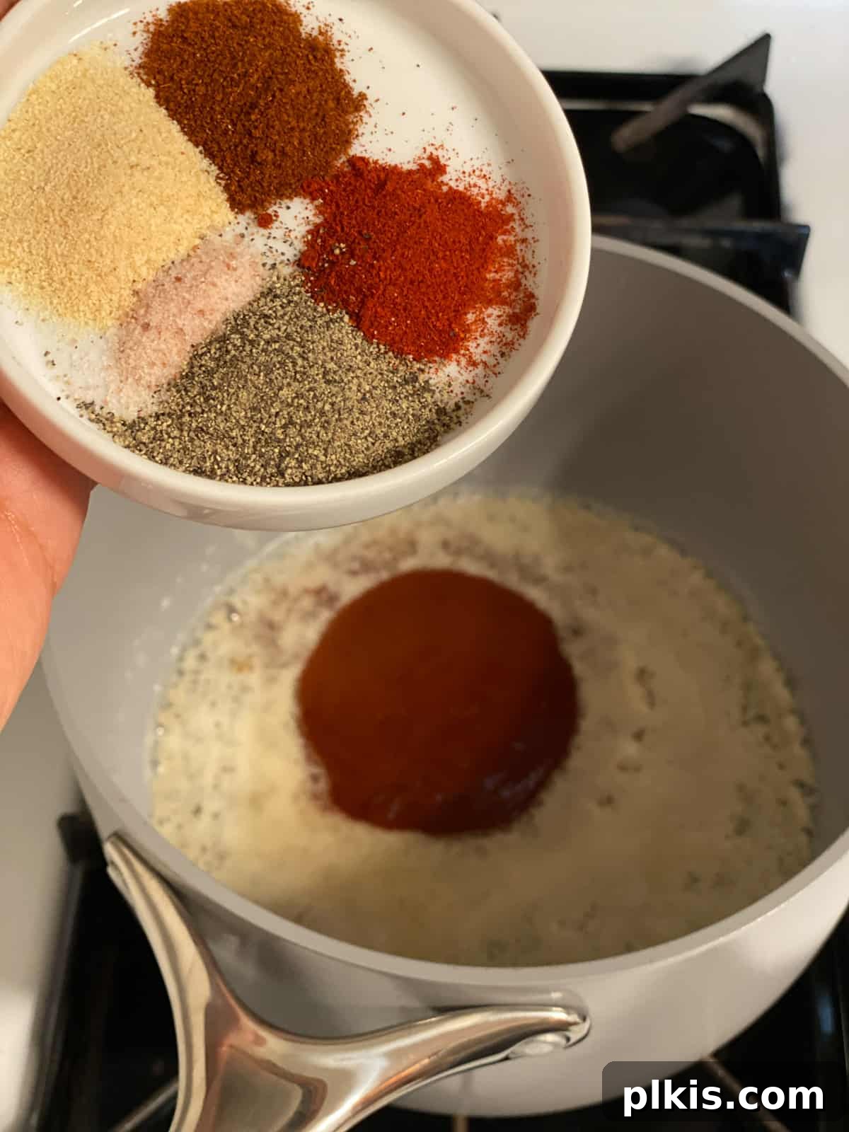 Buffalo Tofu Your Way: Easy Fried, Baked, or Air-Fried 8 Process shot of adding spices like cayenne and paprika to the buffalo sauce mixture
