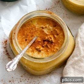 Completed Pumpkin Pie Overnight Oats in storage jar with spoon inside.