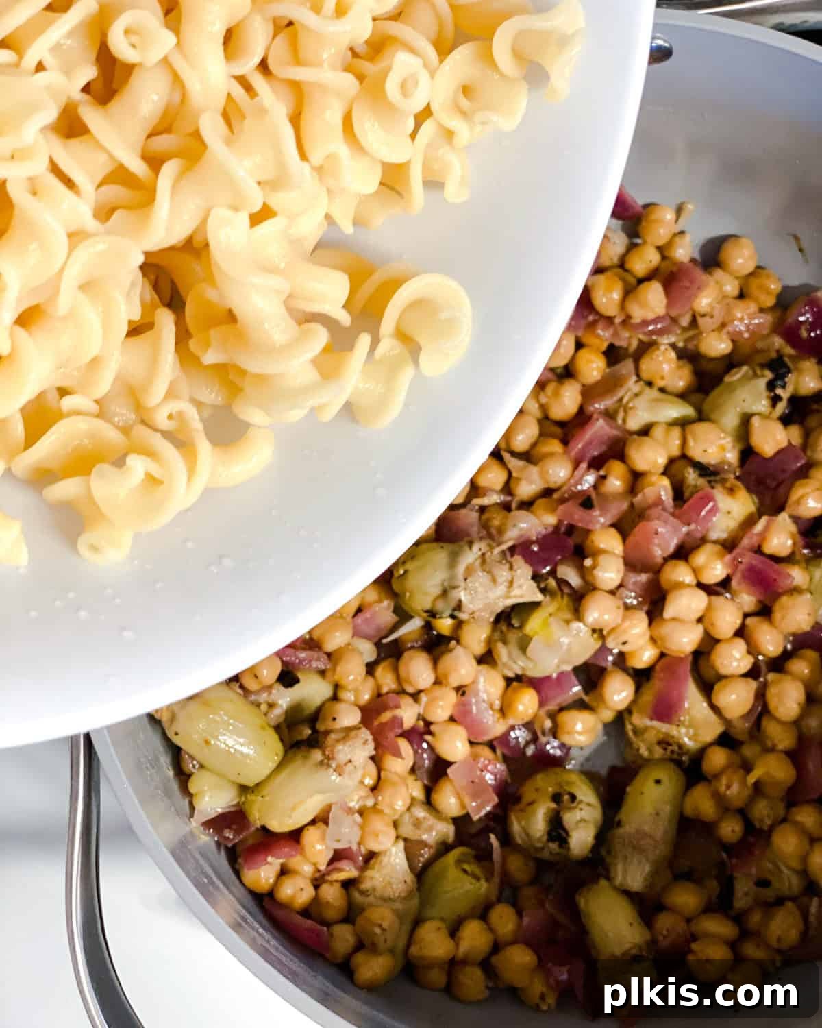 Refreshing Summer Pasta Salad 6 Process shot of adding cooked pasta to the pan with the vegetable mixture.
