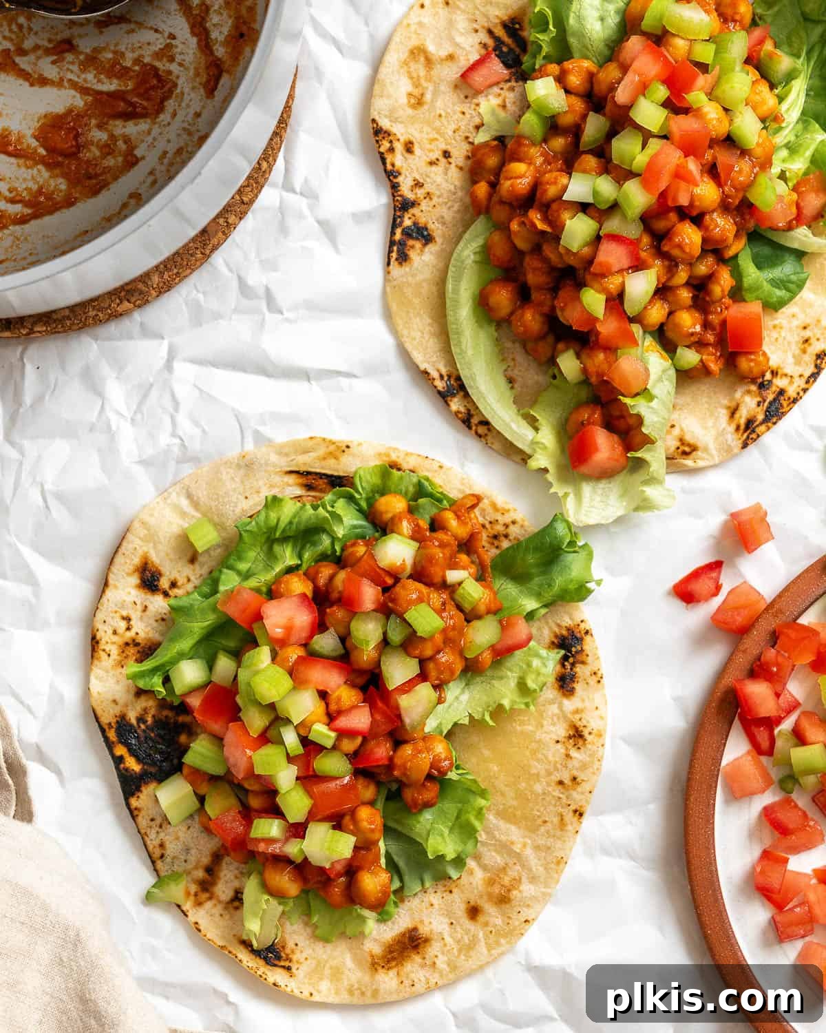 Tangy BBQ Chickpea Wraps 2 Completed BBQ Chickpea Wraps on a white surface, showcasing their delicious and vibrant appearance.