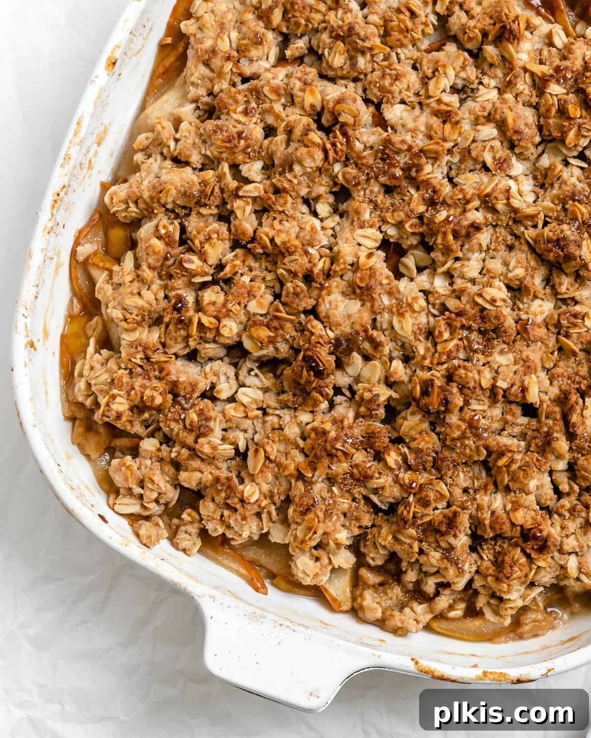 A beautifully baked Easy Pear Crisp [Vegan Pear Crumble] captured in a rustic baking tray, showcasing its golden-brown, crumbly topping and bubbling fruit filling.