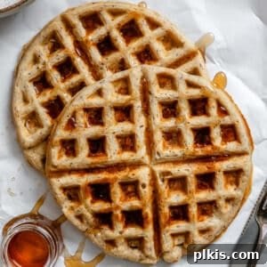 Plant-Based Waffles 11 A stack of golden-brown vegan waffles with maple syrup drizzled on top, ready for serving.