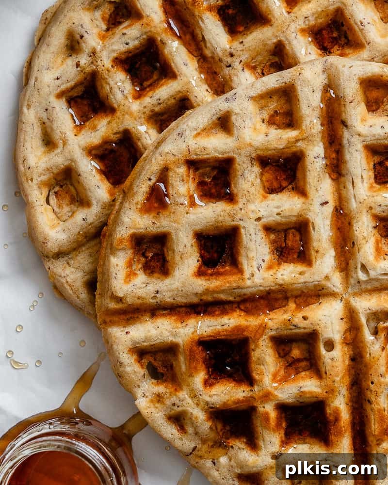Plant-Based Waffles 9 A close-up view of a perfectly cooked vegan waffle, golden brown and crisp, with rich maple syrup artfully drizzled across its deep pockets.