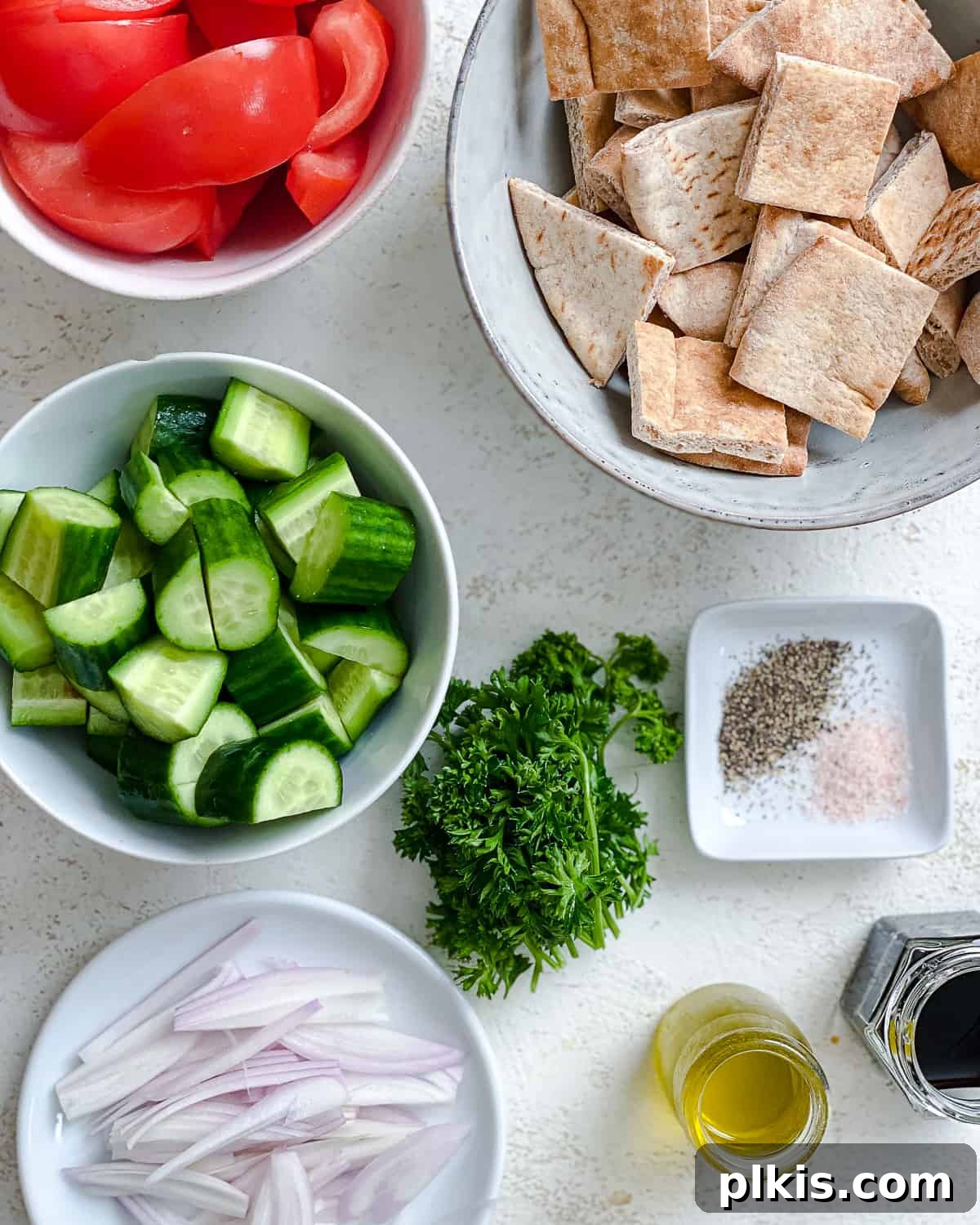 Tuscan Summer Bread Salad 3 ingredients for Panzanella Salad measured out against a white surface