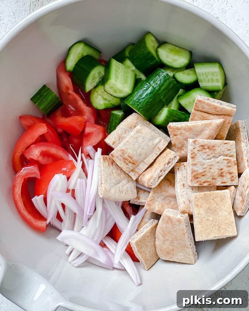 Tuscan Summer Bread Salad 4 ingredients for Panzanella Salad added to a white bowl