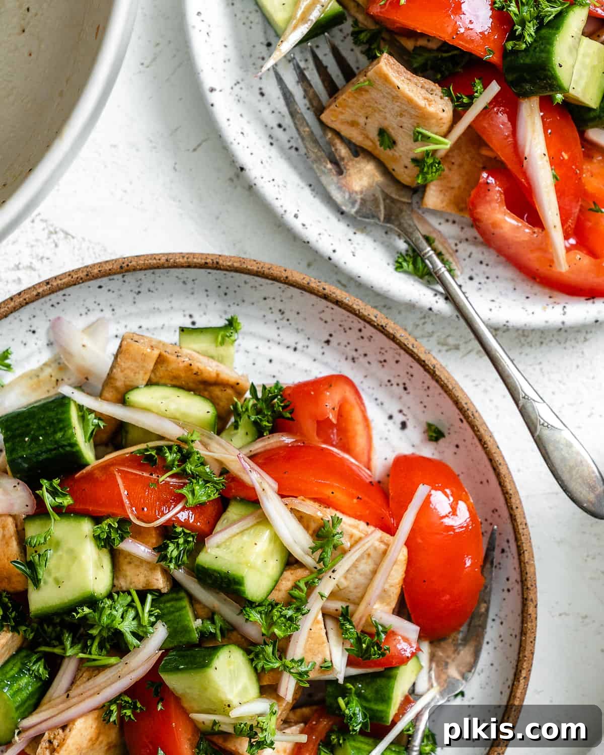 Tuscan Summer Bread Salad 8 completed Panzanella Salad plated on two plates against a white surface