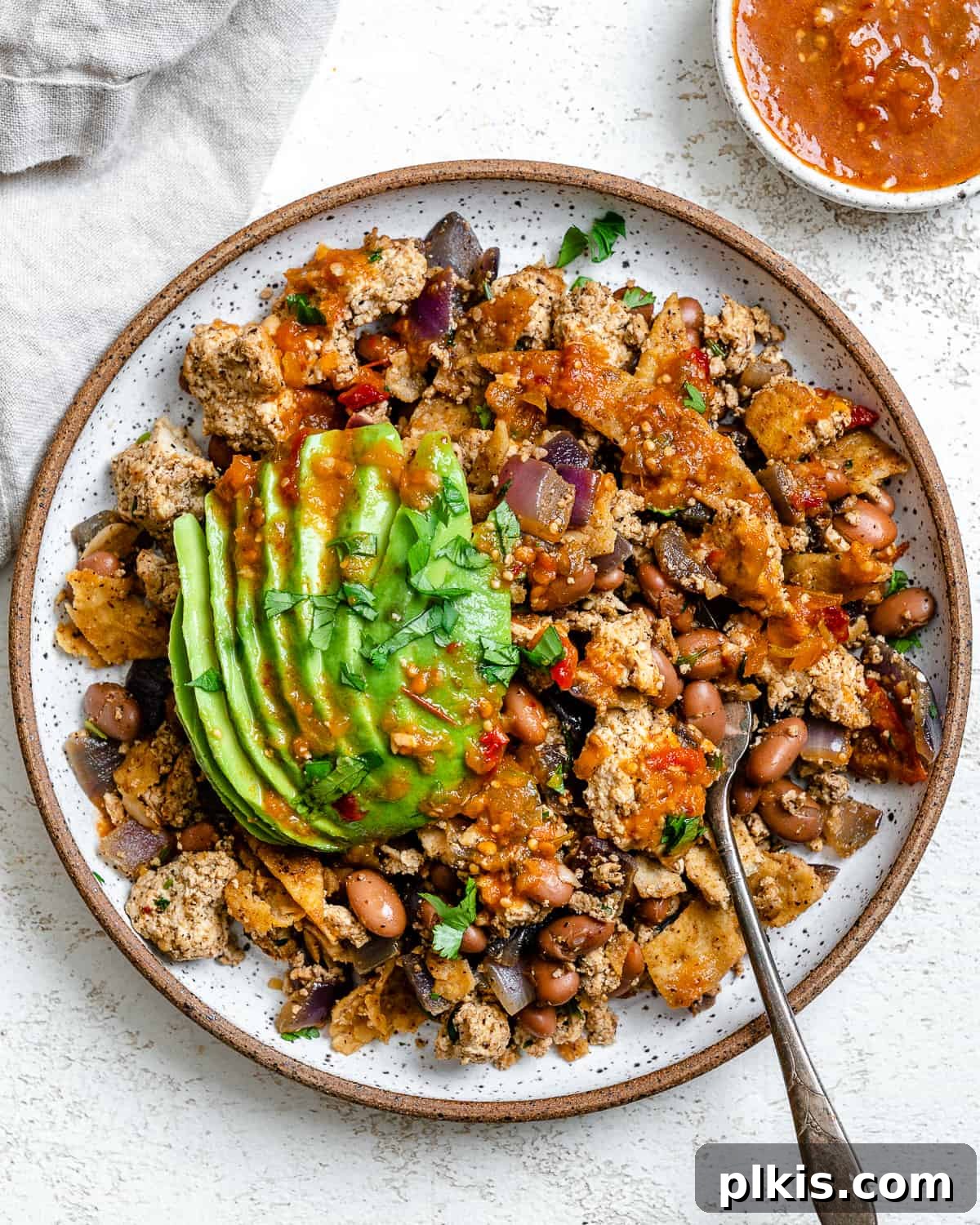 Vegan Chilaquiles Red or Green 2 Completed Vegan Chilaquiles (Rojos or Verdes) plated beautifully against a white background, garnished with fresh avocado and cilantro.