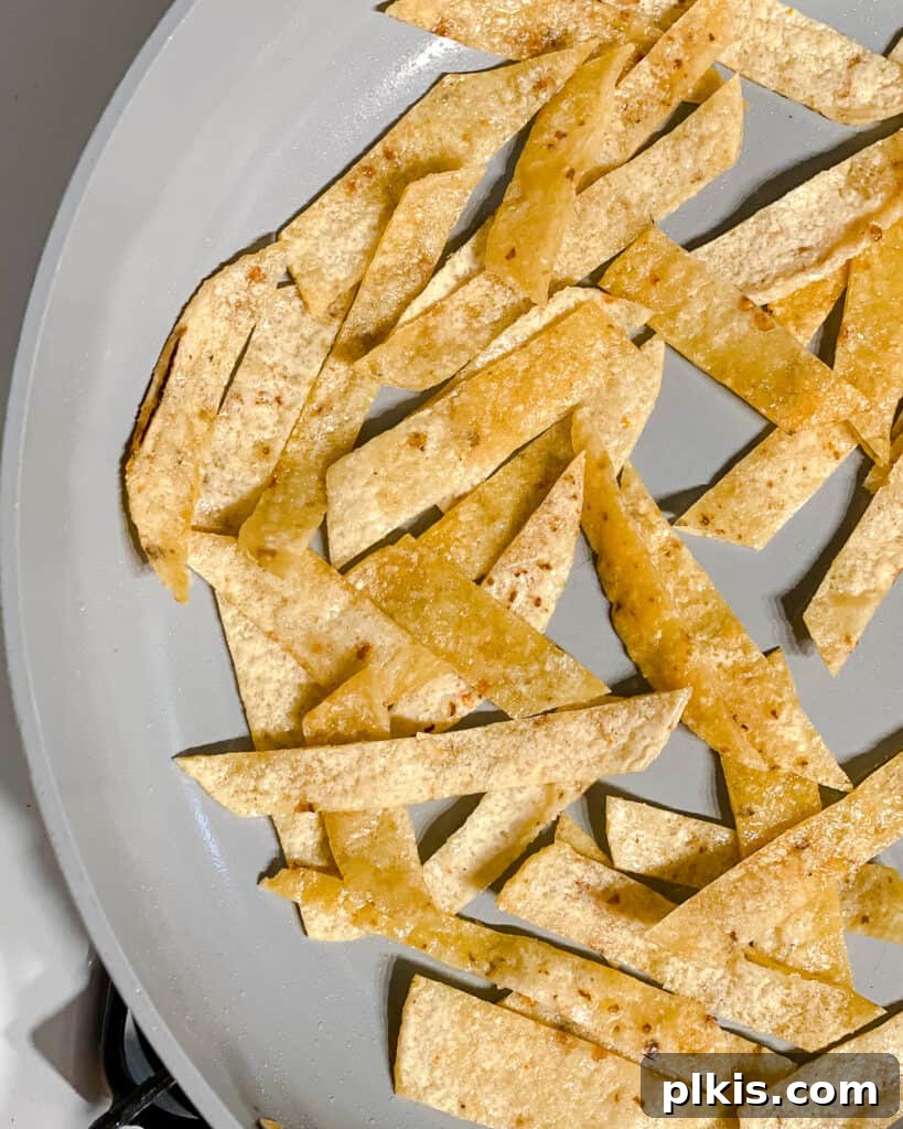 Vegan Chilaquiles Red or Green 6 Process shot depicting tortilla strips actively cooking and browning in the frying pan, achieving perfect crispness.