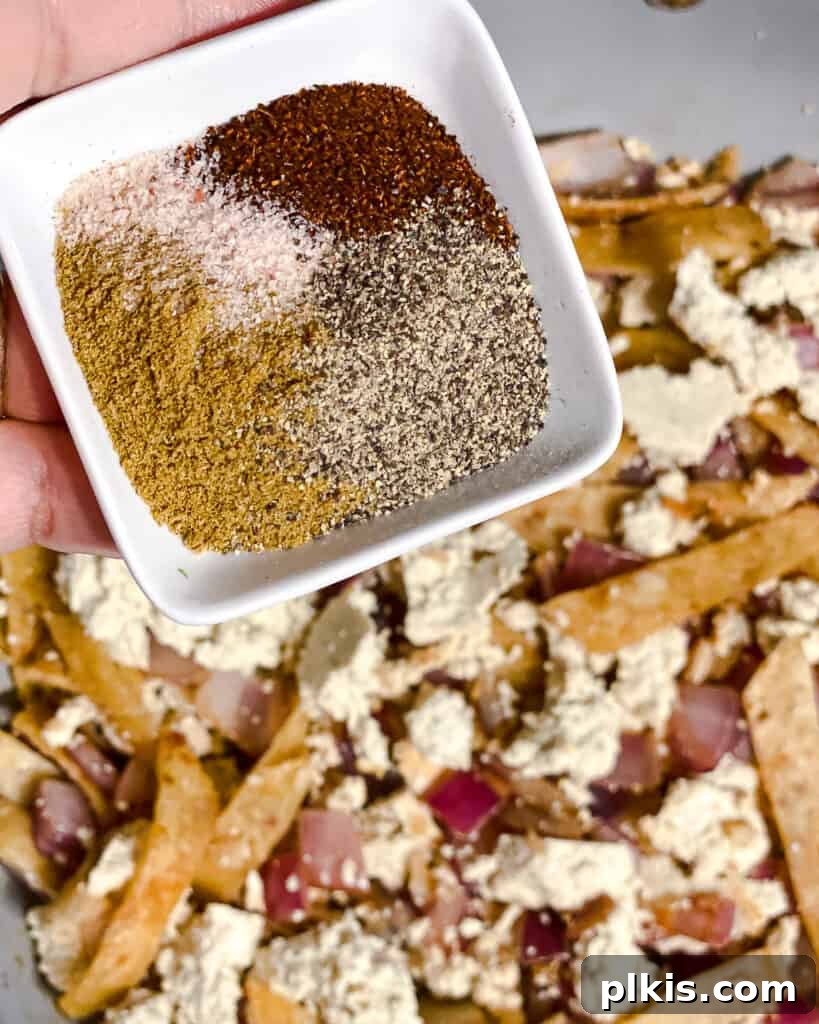 Vegan Chilaquiles Red or Green 9 Process shot showing spices being sprinkled over the tofu and vegetables in the pan, enhancing the flavor.