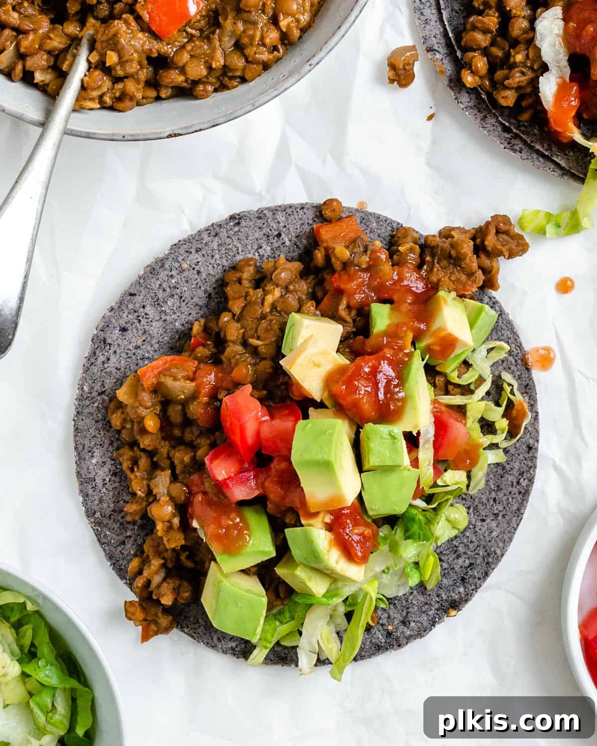 Plant-Powered Lentil Tacos 2 Delicious Lentil Tacos served on tortillas against a crisp white background, garnished with fresh cilantro.