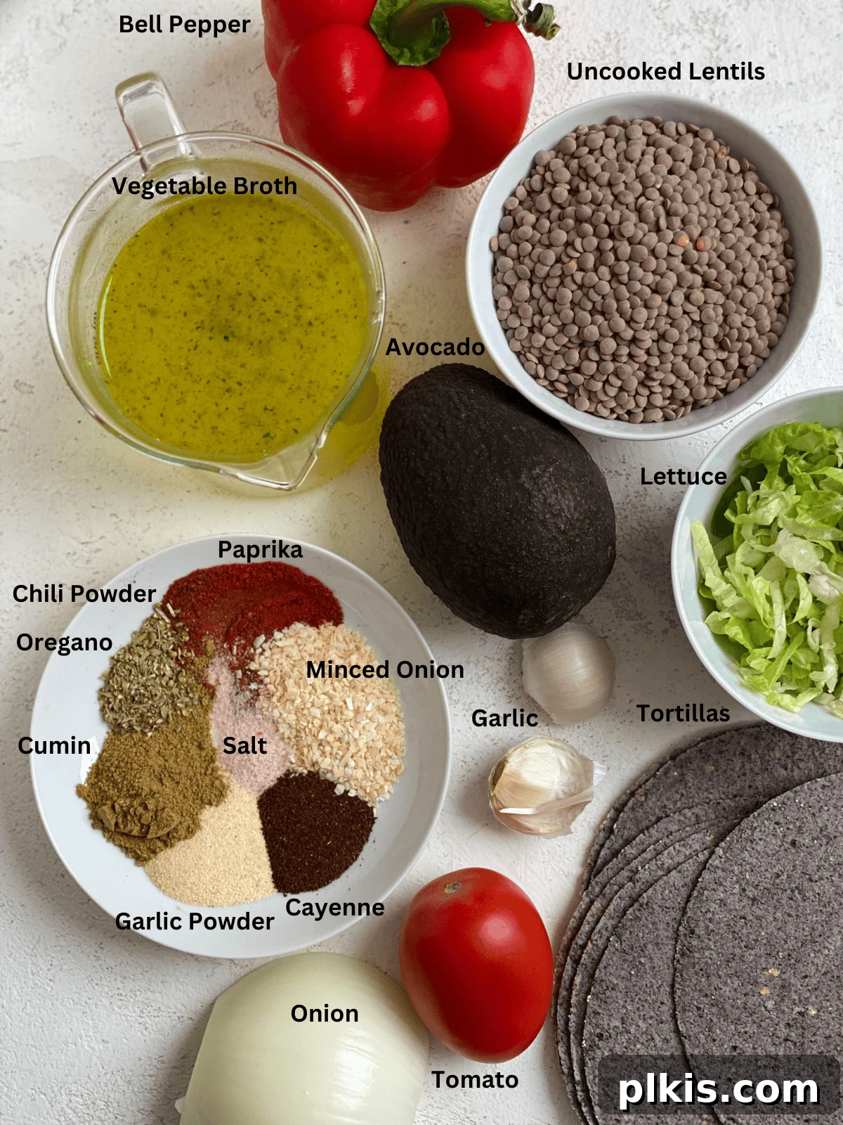 Plant-Powered Lentil Tacos 3 A vibrant display of fresh ingredients for Lentil Tacos, neatly arranged on a white surface, including lentils, spices, vegetables, and tortillas.