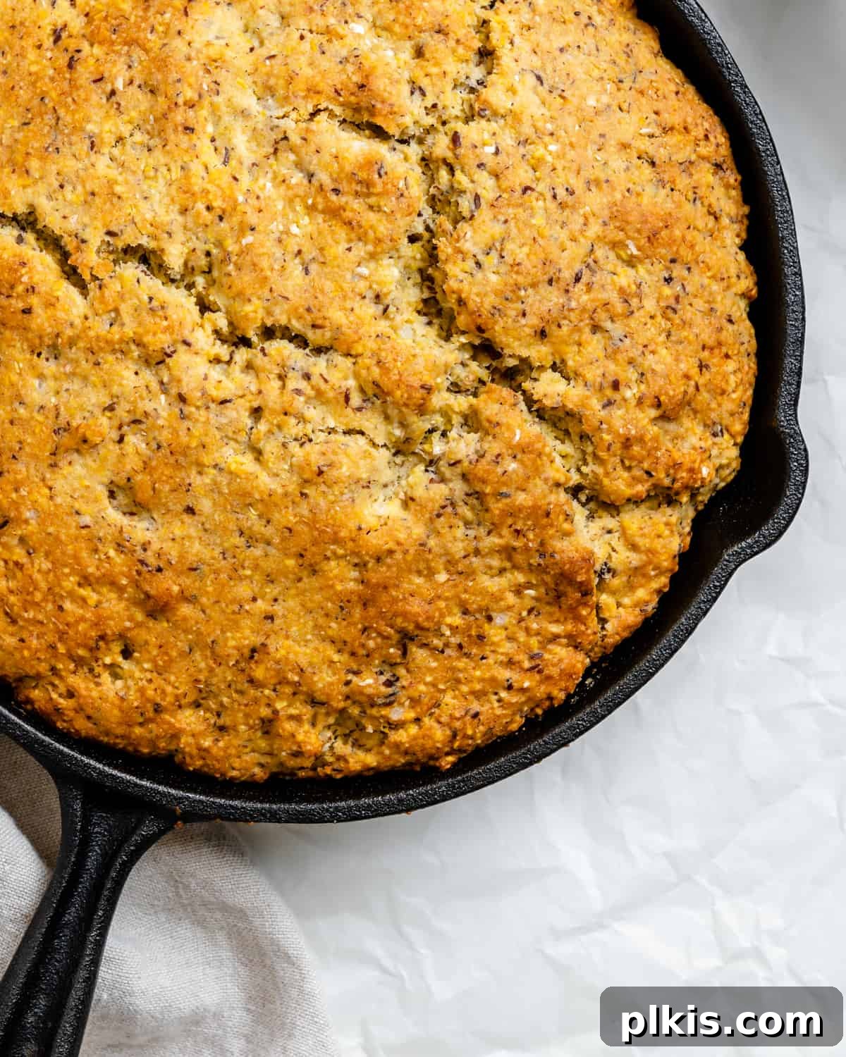 Golden Crust Vegan Cornbread in a Cast Iron Skillet 14 completed Vegan Cornbread Recipe in a Cast Iron Skillet against a white background, ready to be served
