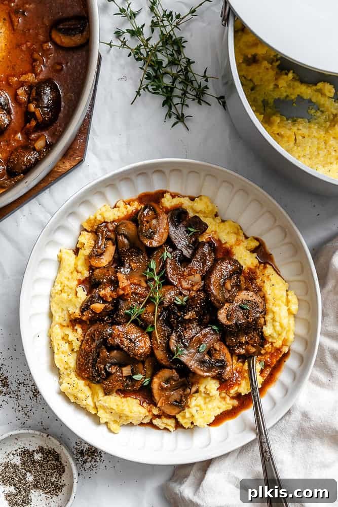 Velvety Polenta with Earthy Mushrooms 2 Completed Creamy Polenta with Mushrooms on a plate, garnished with fresh herbs.
