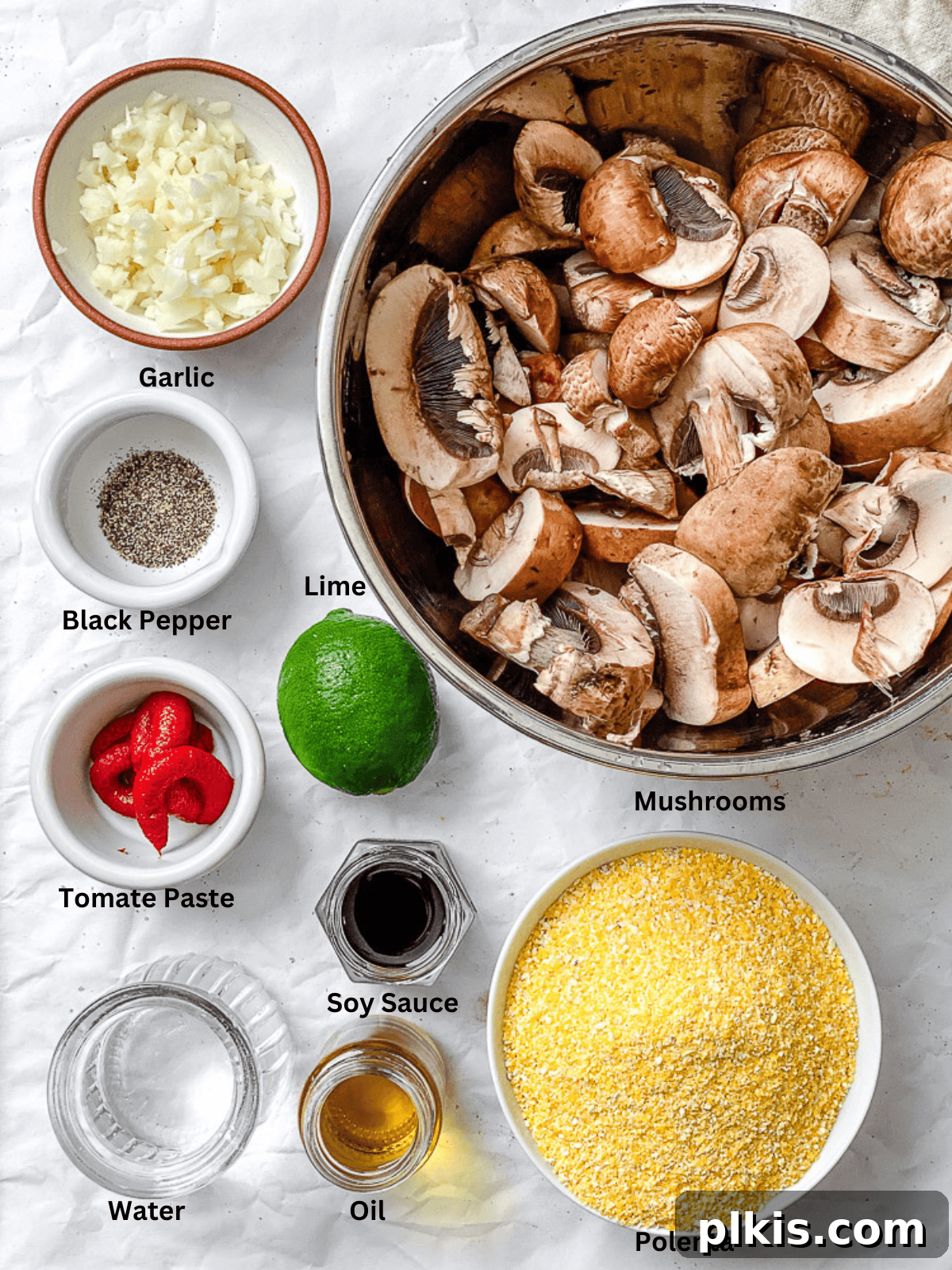 Velvety Polenta with Earthy Mushrooms 3 Ingredients for Creamy Polenta with Mushrooms measured out on a white surface, including sliced mushrooms, polenta, olive oil, and various seasonings.