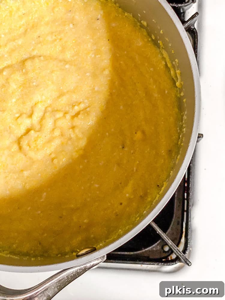 Velvety Polenta with Earthy Mushrooms 4 Process shot showing polenta simmering in a saucepan.