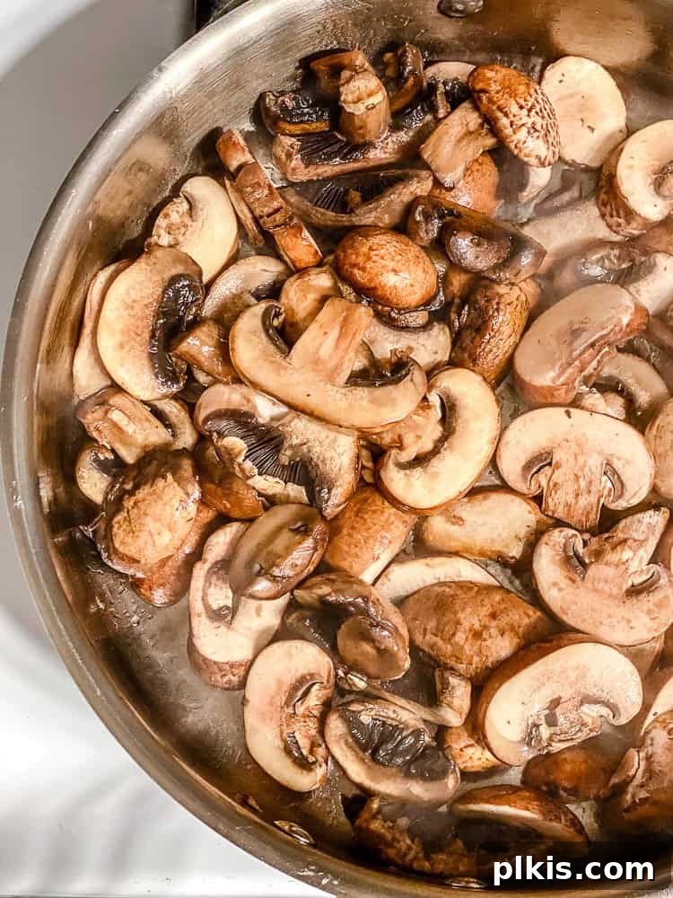 Velvety Polenta with Earthy Mushrooms 5 Process shot showing sliced mushrooms cooking in a skillet.