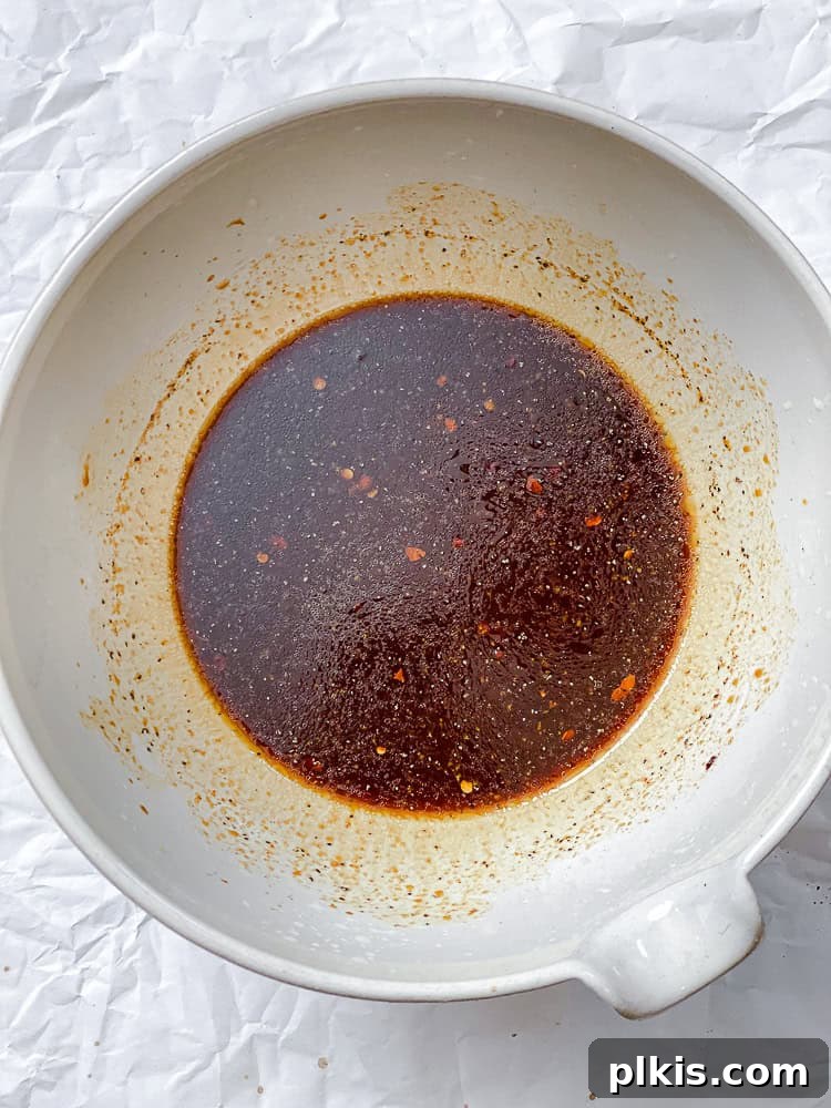 Process shot showing sauce for Crispy Brussels Sprouts in bowl.