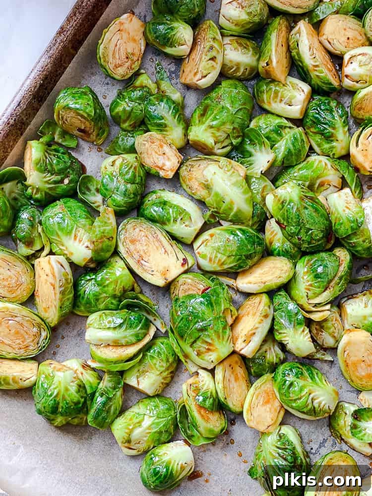 Process shot showing Brussels sprouts spread in a single layer on a baking tray.