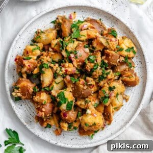 French potato salad on a white plate, ready to be served.