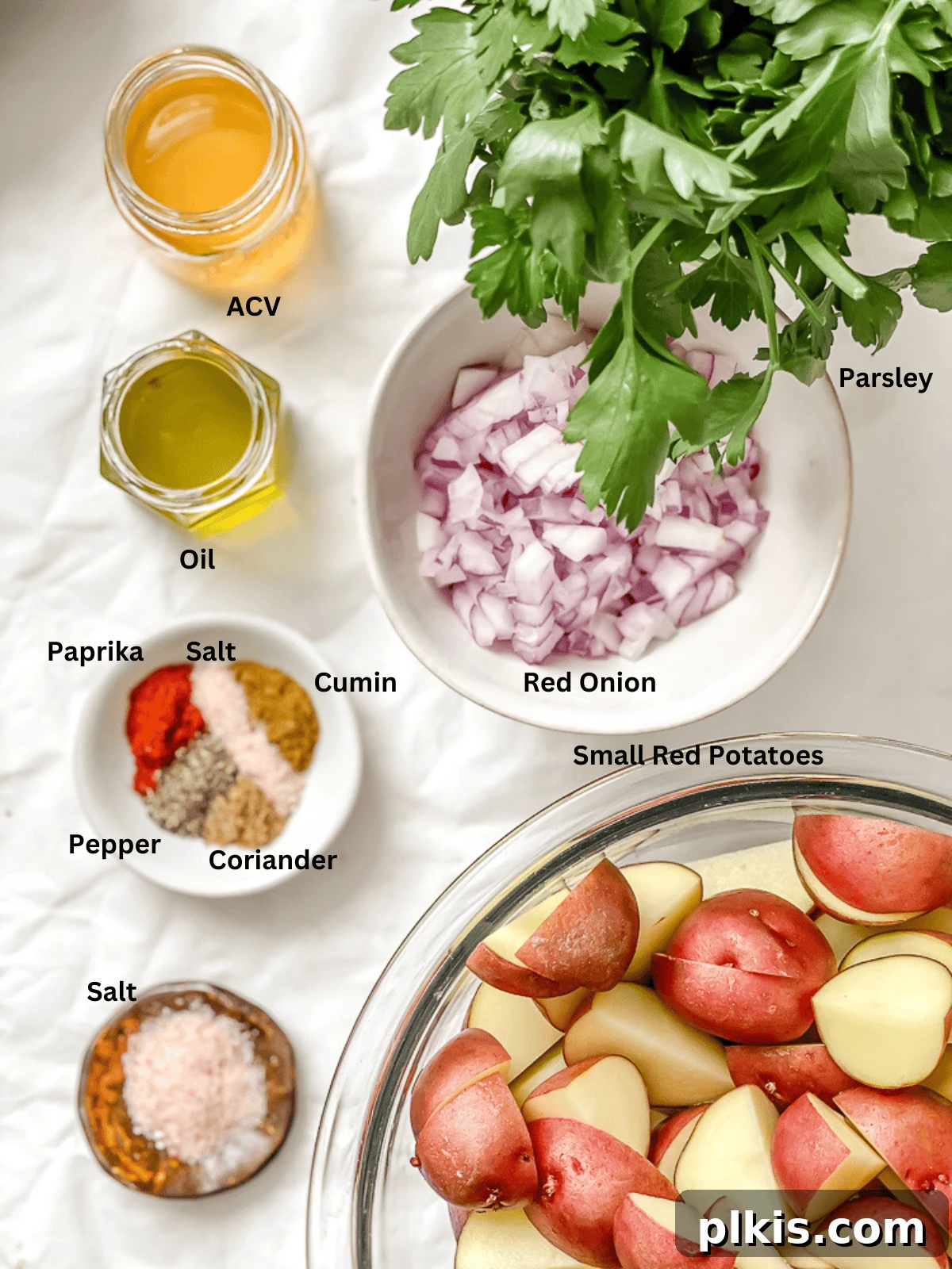 Individual bowls containing all the fresh ingredients for French potato salad, clearly labeled and ready for preparation.