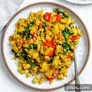 Fluffy and Flavorful Vegan Tofu Scramble with Garden Veggies 12 completed The Best Vegan Tofu Scramble with Veggies plated on a plate against a light background