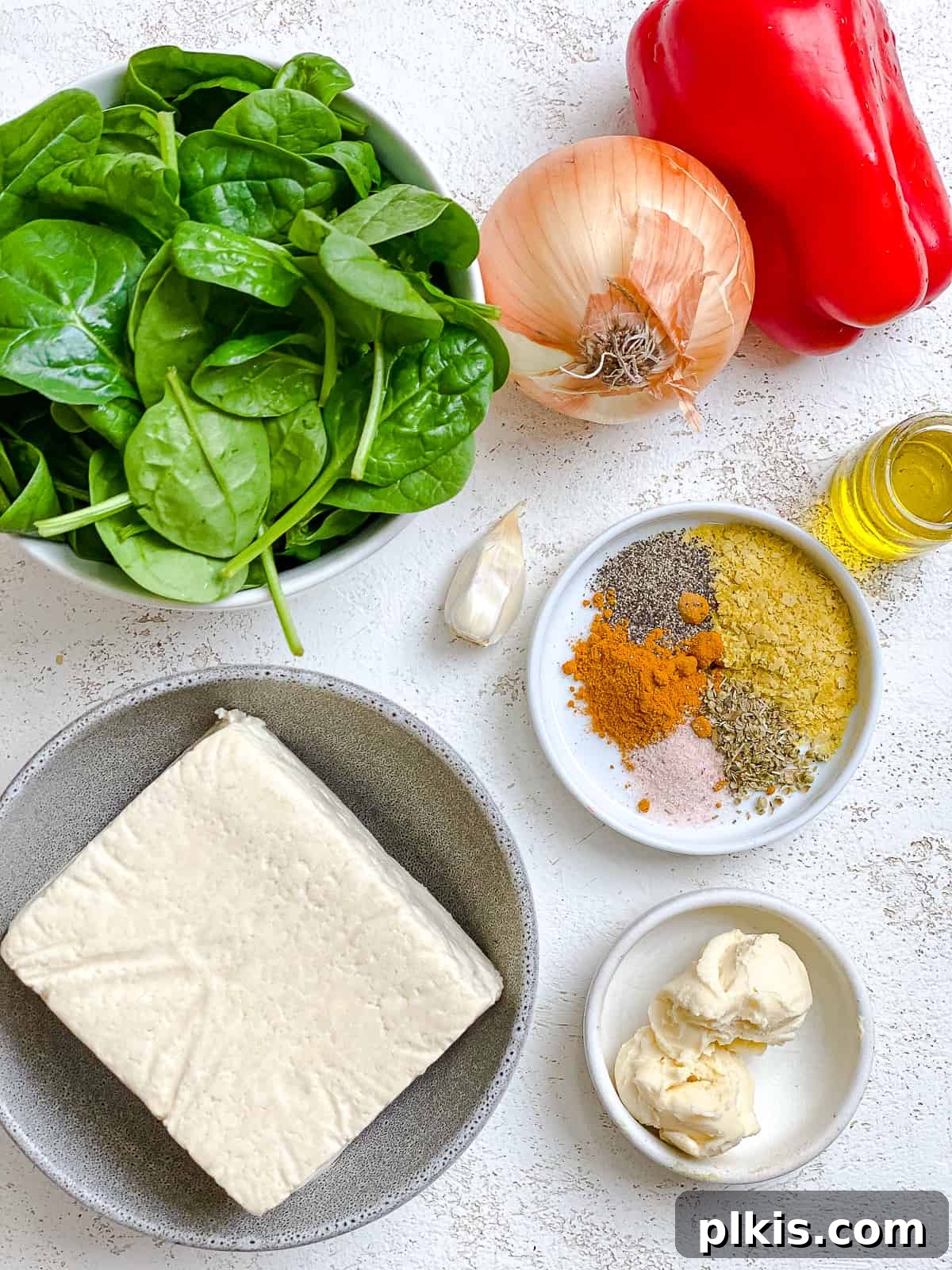 Fluffy and Flavorful Vegan Tofu Scramble with Garden Veggies 3 All the ingredients for the best vegan tofu scramble with veggies, neatly measured and arranged on a white surface, ready for cooking.