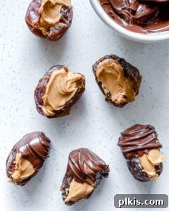 process of dipping a peanut butter stuffed date into melted chocolate on a white surface