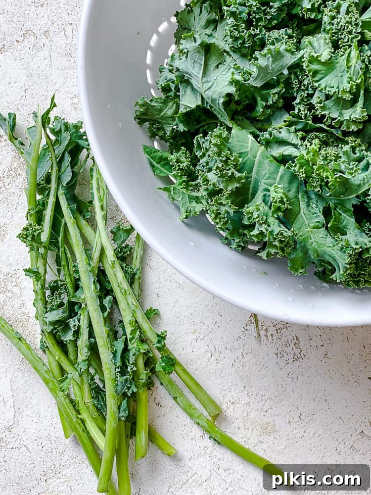 Process shot of de-stemming kale leaves, preparing them for crispy kale chips.