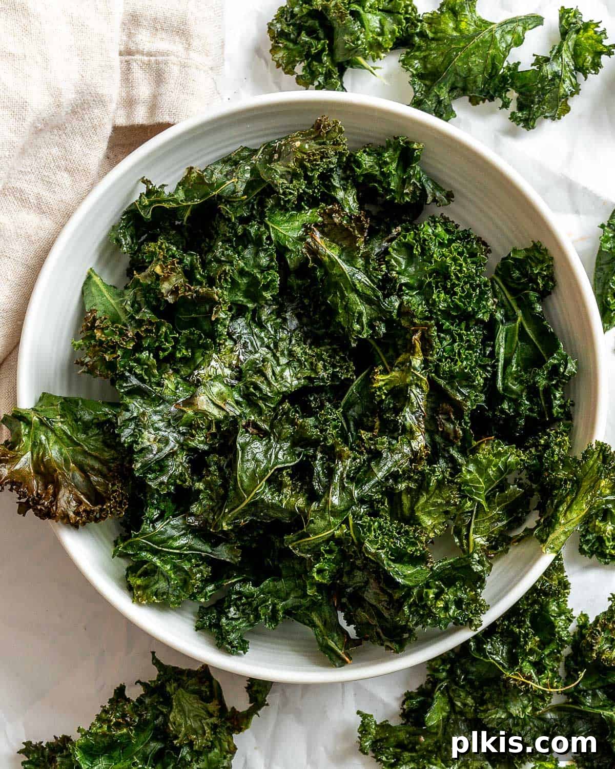 Another enticing view of a bowl of completed Crispy Baked Kale Chips, showing their golden and green hues.