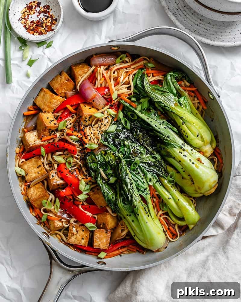 Completed Vegetable Yaki Udon Noodles [Stir-Fry] on a plate, garnished with green onions and sesame seeds.