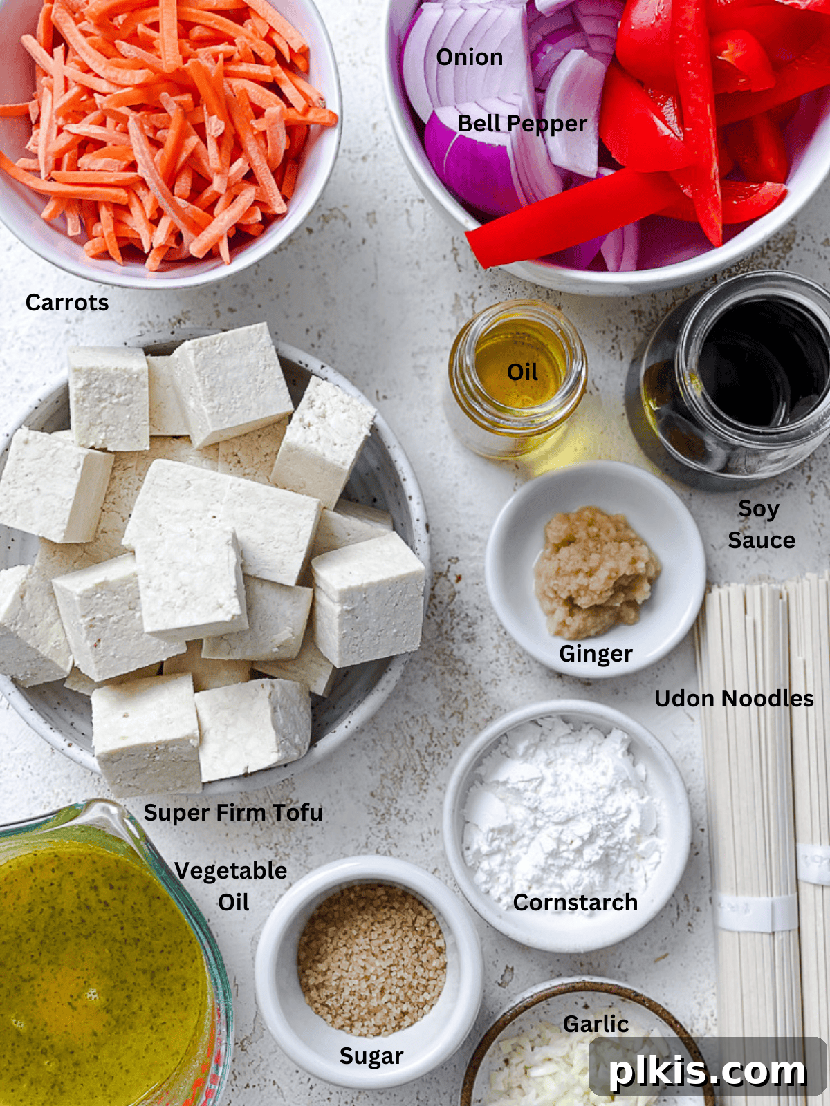 Ingredients for Vegetable Yaki Udon Noodles [Stir-Fry] measured out on a white surface, including noodles, sauce ingredients, tofu, and fresh vegetables.