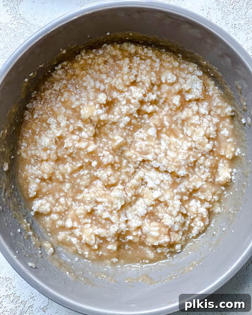 Effortless Vegan Banana Bread Applesauce Enhanced 5 Process shot of adding dry ingredients to a medium mixing bowl, illustrating the initial steps of combining ingredients for the banana bread batter.