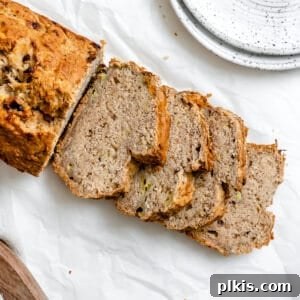 Effortless Vegan Banana Bread Applesauce Enhanced 9 Completed sliced Easy Vegan Banana Bread (With Applesauce) in a loaf pan against a white background