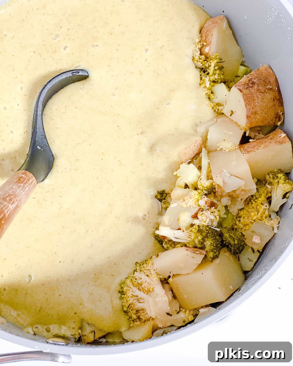 Process shot: Stirring the partially blended soup in the pot to combine creamy and chunky textures.