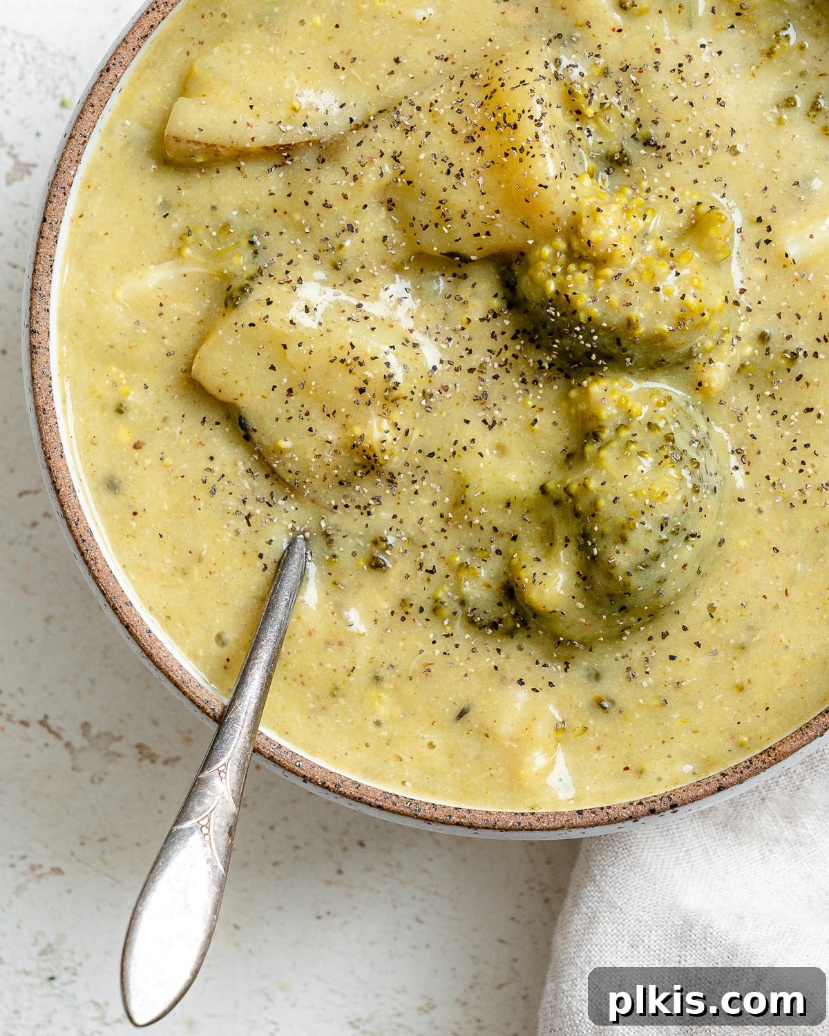 Another view of the completed Vegan Broccoli Potato Soup in a bowl, with a spoon.