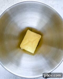 Luscious Vegan Lemon Buttercream 4 Softened vegan butter in a gleaming stainless steel mixing bowl, ready to be creamed for the buttercream frosting.
