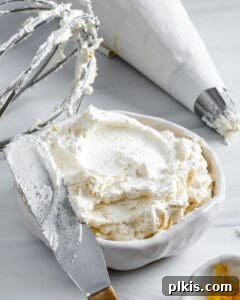 Luscious Vegan Lemon Buttercream 6 A bowl of freshly made, light and fluffy vegan lemon buttercream frosting, showcasing its smooth texture and vibrant yellow color, ready to be used.
